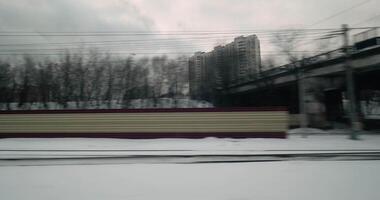 Passing by winter city, view from moving train video