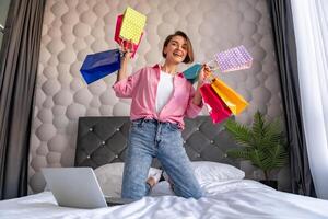 pretty happy woman jumping on bed at homeshopping online photo