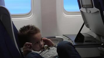 Child entertaining with mobile phone in the plane video