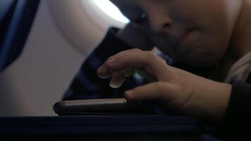 Close up view of small boy playing with smartphone on the table video