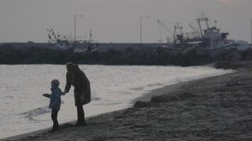 mãe com filho caminhando e jogando em a de praia do egeu mar dentro a inverno ne calikratia, Grécia video