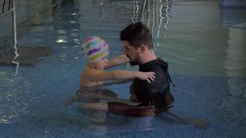 At the medical clinic Evexia in pool doctor checks how works feet of a little boy video