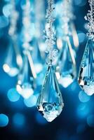 Sparkling glass icicle ornaments catching the ambient light hung delicely isolated on cool-toned winter-blue gradient background photo