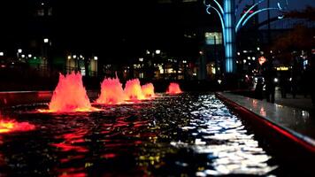 paisaje nocturno rojo fuente luces en vista de cataratas edificio, Niágara, en bucle video