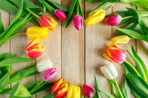 Heart of tulip flowers on a wooden background. Valentine's day, place for text. photo