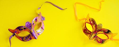 Carnival mask on yellow background. Mardi Gras concept. Fat Tuesday symbol. photo