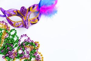 máscara de carnaval con plumas y cuentas de colores sobre fondo blanco. mardi gras o símbolo del martes gordo. foto