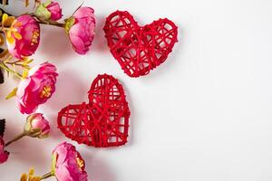 Flowers and red hearts on a white background for Valentine's Day photo