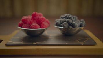 färsk mogen hallon och blåbär stående på trä- tabell video