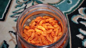 Red Spicy Fried Macaroni Texture in a glass container photo