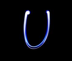 U Uniform alphabet hand writing blue light  over black background. photo