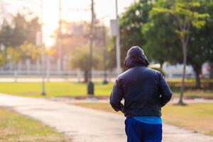 Fit man running and jogging in the park. photo