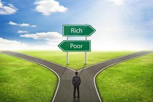 Businessman concept, Sign Rich or Poor road to the correct way. photo
