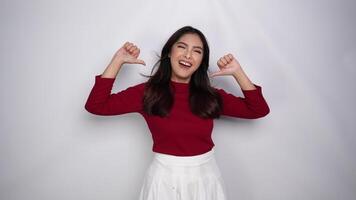 A young Asian woman with a happy successful expression wearing red top is cheering and supporting, isolated by white background video