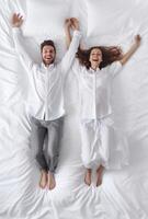 AI Generative Couple having fun while pillow fight in the bed  Boyfriend and girlfriend enjoying the company of each other photo