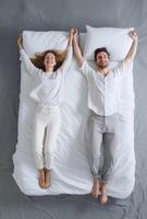 AI Generative Happy couple in love having fun jumping on bed at home Handsome man and beautiful woman are enjoying spending time together photo
