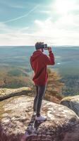 AI Generative Hiker taking a selfie with smart phone mobile on the top of the mountain  Man hiking outdoors  People sport and technology concept photo