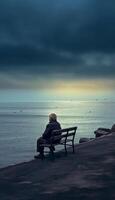 AI Generative Sad old man sitting by the sea Concept about people sadness and loneliness photo