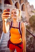 AI Generative Travel blogger taking a selfie outdoors  Happy woman with backpack smiling at camera  People travel and blogging concept photo