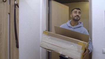 el mensajero trajo el paquete. medios de comunicación. un adulto hermoso hombre en demasiado grande ropa trajo cajas a un nuevo departamento. foto