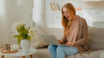 Caucasian woman in glasses happy girl lady student businesswoman freelancer female with laptop sitting on couch celebrating good news exams admission business great results win success victory winning photo
