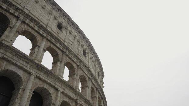Italy, Rome - July 29, 2022. Bottom view of Roman architecture of Colosseum. Action. Part of Colosseum on background on sky. Beautiful architecture of famous and recognizable Colosseum in Rome photo