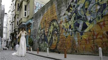 Italia, roma-agosto 12,2022. Boda creativo. acción.joven novias posando en diferente lugares, uno caminando en un verde bosque y el segundo siguiente a un pintada pared. foto