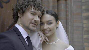 Close-up of beautiful couple of newlyweds. Action. Newlyweds in wedding dresses at church. Happy newlyweds during wedding ceremony photo