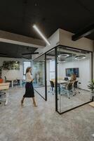 Young woman with digital tablet walking in the modern office photo