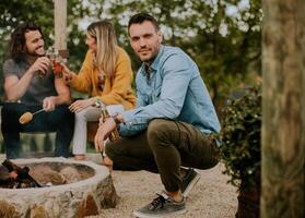 Friends having good time and baking corns in the house backyard photo