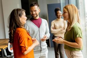 Cute Africam American woman with her young multiethnic startup team working in the modern office photo