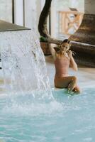 Young woman relaxing by the indoor swimming pool photo