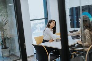 Young business women discussing in cubicle at the office photo