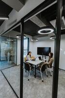 Young business women discussing in cubicle at the office photo