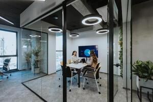 Young business women discussing in cubicle at the office photo