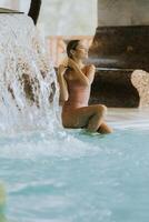 Young woman relaxing by the indoor swimming pool photo