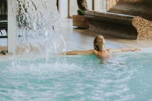 Young woman relaxing in the indoor swimming pool photo