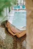 Young woman relaxing by the indoor swimming pool photo