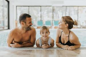 familia en el interior nadando piscina foto