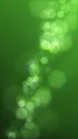 Vertikale Video - - defokussiert Grün Bokeh Beleuchtung Hintergrund. diese Bewegung Animation mit sechseckig Bokeh Partikel ist voll hd und Schleife. geeignet wie ein abstrakt st Patrick's Tag Hintergrund.