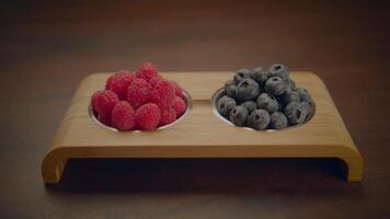 Fresh Ripe Raspberries and Blueberries Standing on Wooden Table video