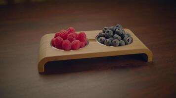 frisch reif Himbeeren und Blaubeeren Stehen auf hölzern Tabelle video