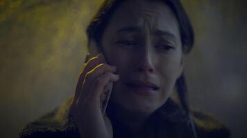 triste mujer hablando en célula teléfono fuera de a noche en lloviendo clima video