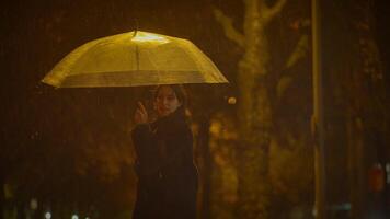 glücklich sorglos Frau Tanzen mit Regenschirm draußen im regnerisch Nacht video