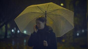 malheureux inquiet femelle la personne pleurs tandis que appel en portant parapluie video