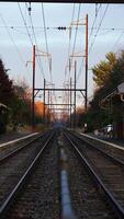 The railway view with the track and the colorful woods as background in the autumn morning photo