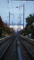 The railway view with the track and the colorful woods as background in the autumn morning photo