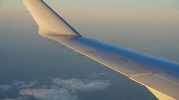 el avión ala ver miró desde el volador avión ventana con el puesta de sol luz de sol en eso foto