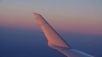 The airplane wing view looked from the flying plane window with the sunset sunlight on it photo