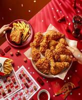 PAKISTAN, KARACHI DECEMBER 29, 2023 Crispy fried chicken and french fries on red background .KFC is popular fast food chain known as Kentucky Fried Chicken.Selective focus photo